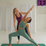 Yoga Teacher correcting a student in a TriYoga studio